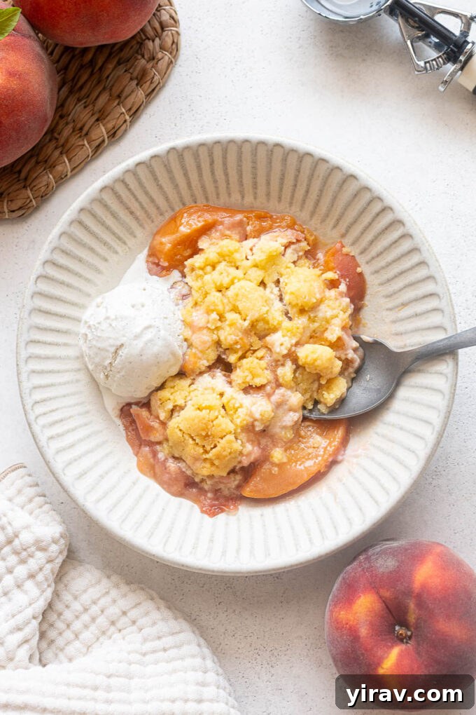 Fresh Peach Cobbler Recipe with Golden Biscuit Topping 2 Fresh peach cobbler with shortbread cookie-style topping and vanilla ice cream.