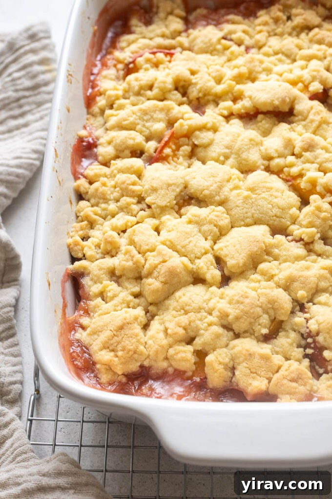 Fresh Peach Cobbler Recipe with Golden Biscuit Topping 10 Peach cobbler with cookie topping in baking dish.
